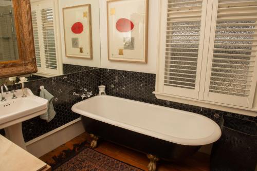 a bathroom with a bath tub and a sink at Villa Victoria B&B in Nelson