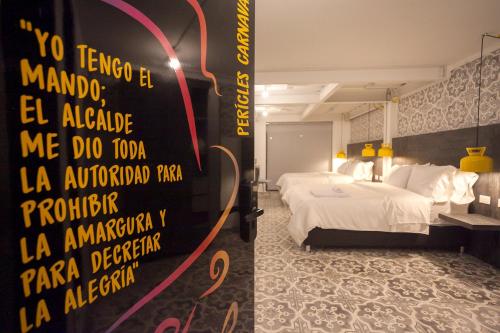 a hotel room with a bed and a sign on the wall at Villaviciosa Hotel Boutique in Pasto