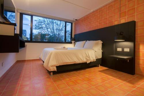 a bedroom with a bed and a large window at Villaviciosa Hotel Boutique in Pasto