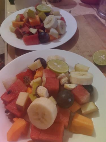 two plates of fruit and vegetables on a table at Agasthi Airport Close in Katunayake
