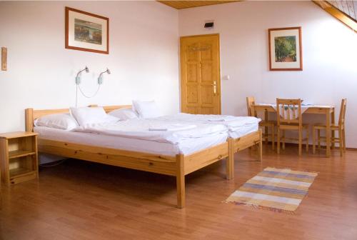 a bedroom with a bed and a table and chairs at Haramia Csapszék és Fogadó in Szombathely