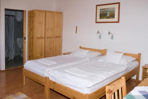 a bedroom with a large bed with white sheets at Haramia Csapszék és Fogadó in Szombathely