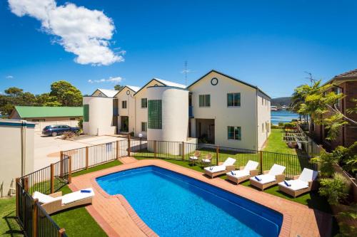 an image of a swimming pool in front of a house at Cetacea Luxury Apartments in Merimbula