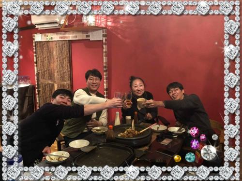 a group of people sitting around a table with wine glasses at HappyCloset&WasamonHostel in Kumamoto