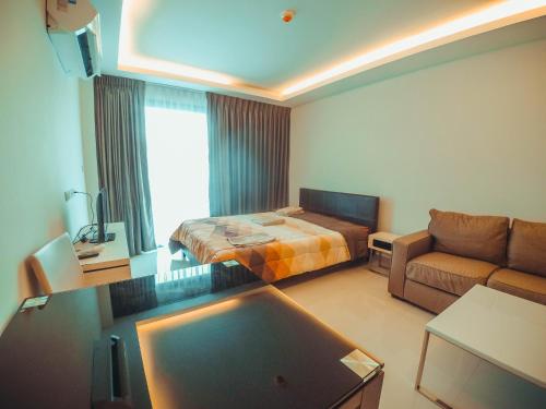 a living room with a bed and a couch at Club Royal suites in North Pattaya