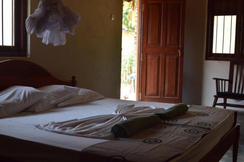 a bed with white sheets and pillows on it at WildEscape, Yala Blocks 3 & 5 in Buttala