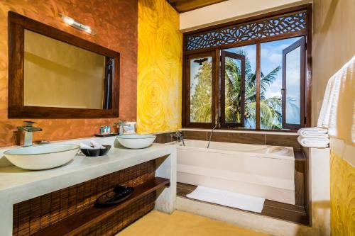 a bathroom with two sinks and a tub and a window at Yasmin Hill Longevity Oasis in Kandy