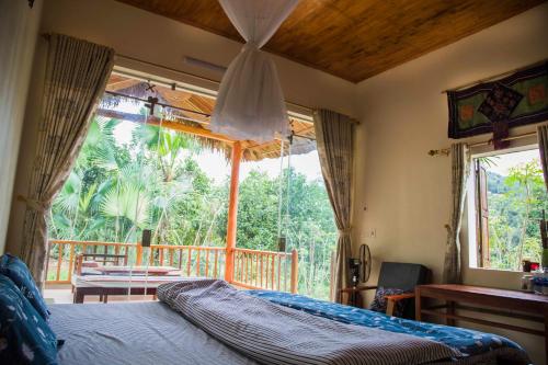 sypialnia z łóżkiem i dużym oknem w obiekcie Cinnamon Eco Lodge w mieście Nậm Hoắc