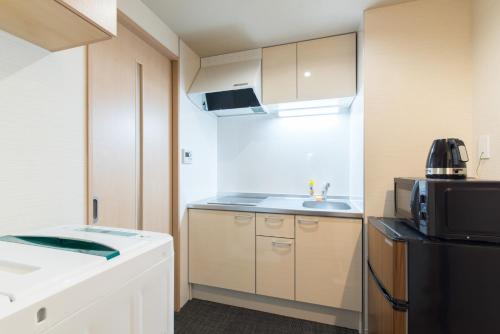 a small kitchen with a sink and a microwave at Stay SAKURA Kyoto Higashiyama Shirakawa in Kyoto