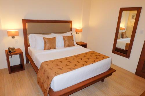 a bedroom with a large bed and a mirror at The Piccolo Hotel of Boracay in Boracay