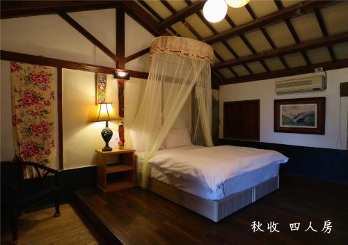 a bedroom with a bed with a mosquito net at 玉蟾園民宿 寵物友善 YuChanYuan B&B in Chishang