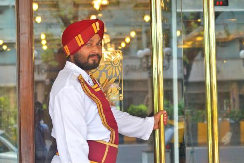 a man with a beard wearing a red and yellow hat at The Ambassador, Marine Drive, Mumbai in Mumbai