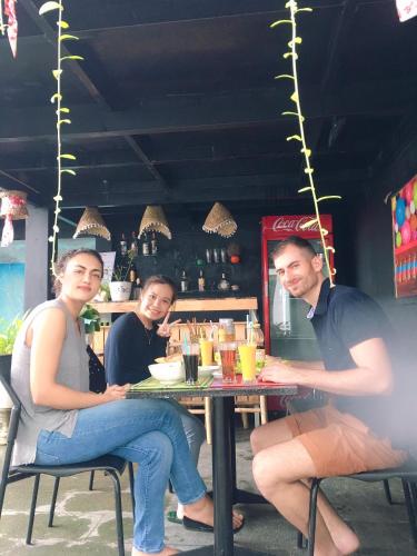 three people sitting at a table in a restaurant at Sunny Riverside Homestay in Hoi An