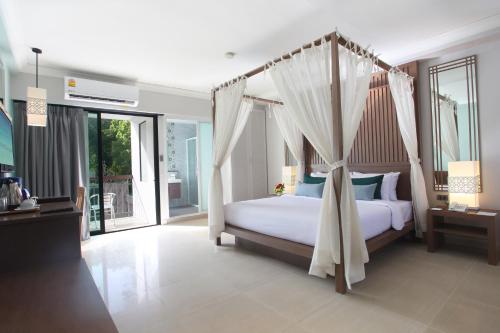 a bedroom with a bed with a canopy at Adema Boutique Karon in Karon Beach