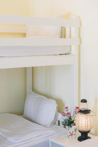 a bedroom with two bunk beds with flowers on a table at Kristi House in Chiang Mai