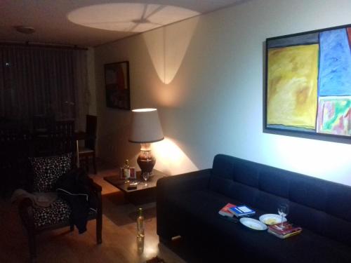 a living room with a blue couch and a table at Cerca a Mitad del Mundo in Quito