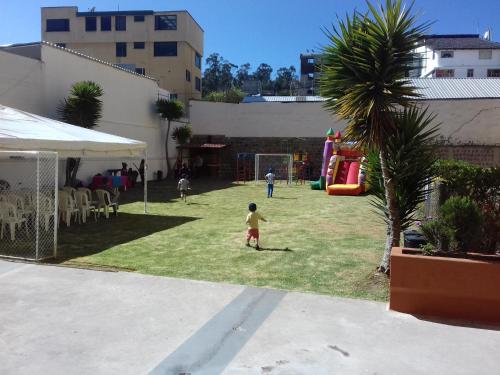 a group of children playing in a yard with a playground at Cerca a Mitad del Mundo in Quito