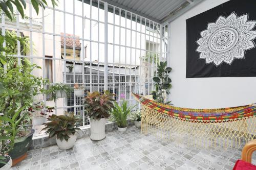 une chambre avec des plantes en pot et un hamac dans l'établissement Saigon April Homestay, à Hô-Chi-Minh-Ville