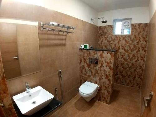 a bathroom with a toilet and a sink at GRAND ELEGANT in Chennai