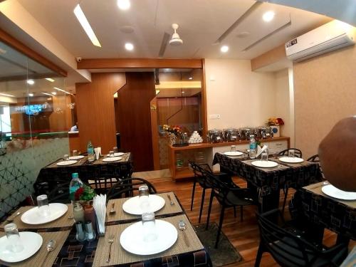 a restaurant with tables and chairs in a room at GRAND ELEGANT in Chennai