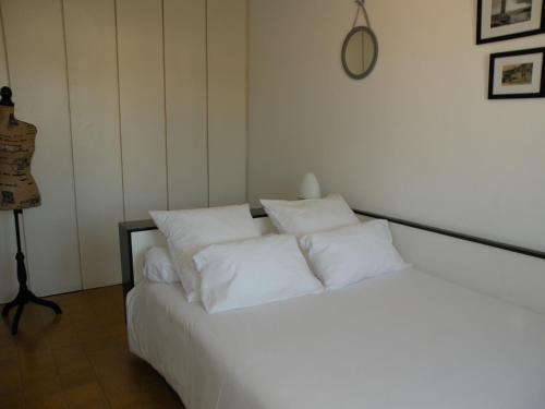 1 cama blanca con 4 almohadas en una habitación en Cassiopée, en Cassis