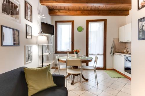 a living room with a table and a kitchen at Studio Mazzini in Forlì