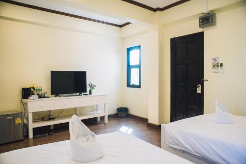 a living room with two beds and a television at Kristi House in Chiang Mai