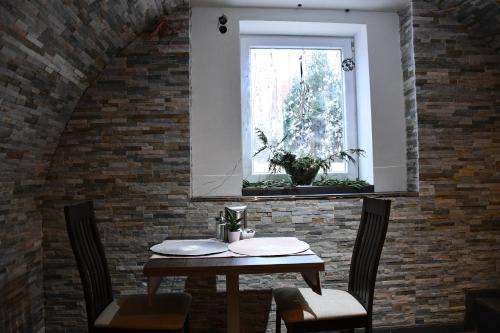a table and chairs in a room with a window at Hotel Myrsini in Kirchentellinsfurt