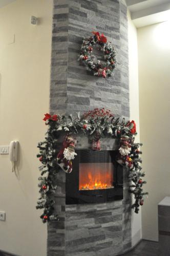 a fireplace with christmas wreaths and a fire place at Comfort Deluxe Kosmos Apartments in Ohrid
