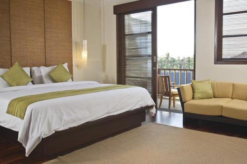 a bedroom with a bed and a chair and a window at Apartment Nusa Dua in Nusa Dua