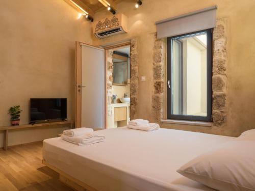 a bedroom with a large white bed and a window at Evans House II in Chania Town