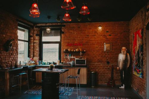 a man standing in a room with a brick wall at Tolstoy Art-Hostel in Kaliningrad