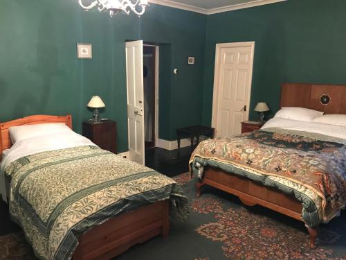 巴克斯頓的住宿－Bank Top Farm B&B Hartington，一间卧室设有两张床,拥有绿色的墙壁