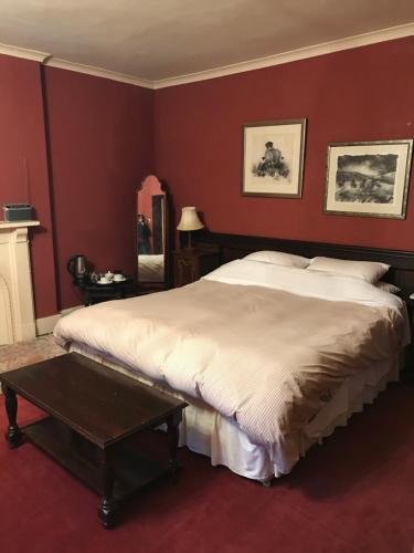 a bedroom with a large bed and a table at Bank Top Farm B&B Hartington in Buxton