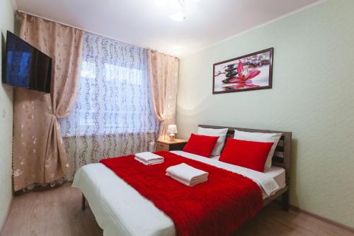 ノヴィ・ウレンゴイにあるFive Stars Skver Stroiteleyのベッドルーム1室(赤い枕のベッド1台、窓付)