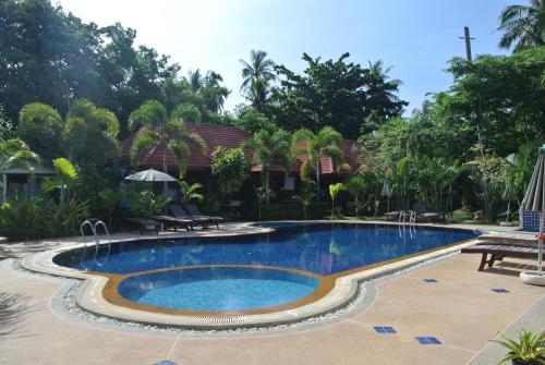 a swimming pool in front of a house at Mac's Bay Resort in Baan Tai