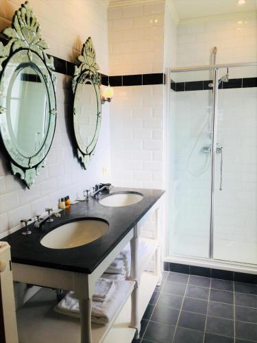 a bathroom with two sinks and a shower at Koetshuis Bosdam in Beveren