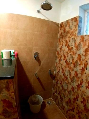 a bathroom with a shower with a tile wall at GRAND ELEGANT in Chennai