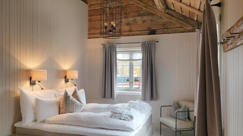a bedroom with a white bed and a window at Nusfjord Arctic Resort in Nussfjord
