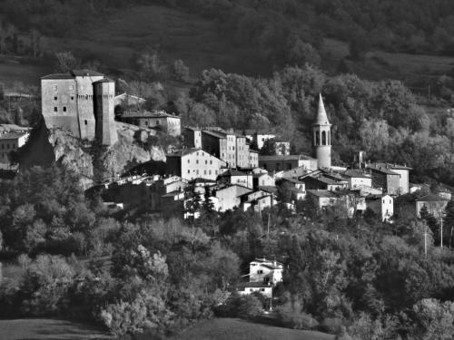 a black and white photo of a town with a castle at B&B Molino Del Gobbo in SantʼAgata Feltria