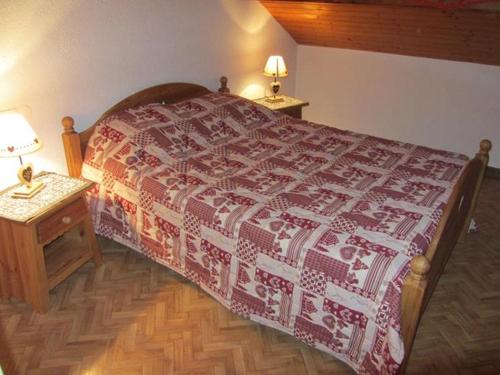 sypialnia z łóżkiem i dwoma stołami z lampkami w obiekcie Gite de Grandvillars w mieście Grandvillars