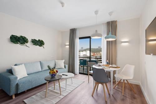 a living room with a blue couch and a table at Palmanova Suites by TRH in Magaluf