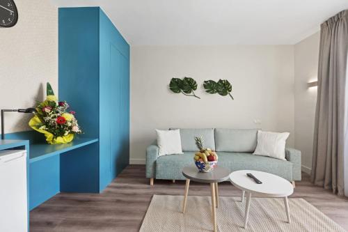 a living room with a blue couch and a table at Palmanova Suites by TRH in Magaluf