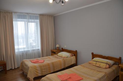 um quarto com 2 camas e uma janela em Hotel Trias em Kiev