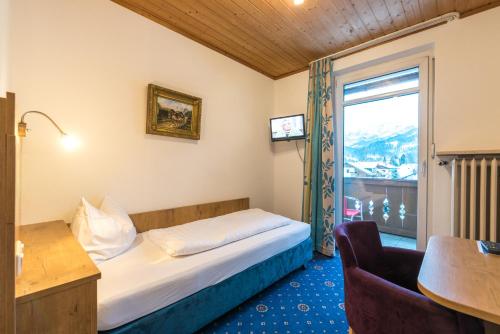 a hotel room with a bed and a window at Hotel garni Almenrausch und Edelweiss in Garmisch-Partenkirchen