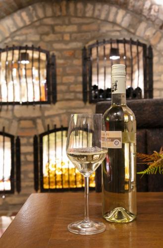 a bottle of wine and a glass on a table at Főtér Rezidencia in Győr