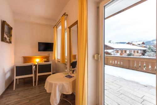 a room with a table and a view of a balcony at Hotel garni Almenrausch und Edelweiss in Garmisch-Partenkirchen