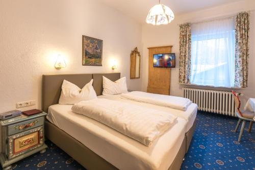 a hotel room with two beds and a window at Hotel garni Almenrausch und Edelweiss in Garmisch-Partenkirchen