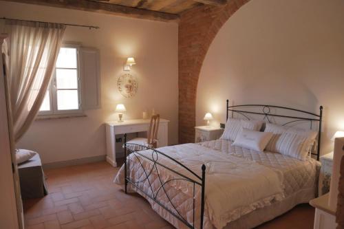 a bedroom with a bed and a window and a desk at Agriturismo Due Comuni in San Gervasio