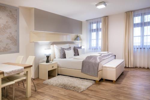 a bedroom with a bed and a table and a desk at Főtér Rezidencia in Győr